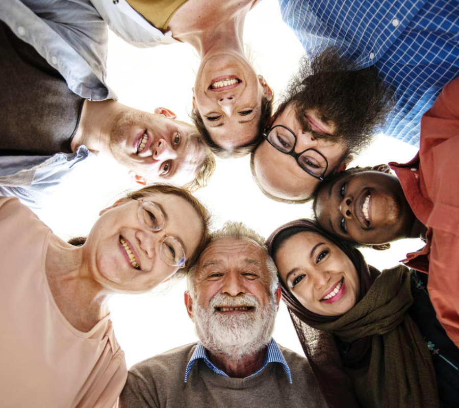A group of people looking down to the camera forming a circle
