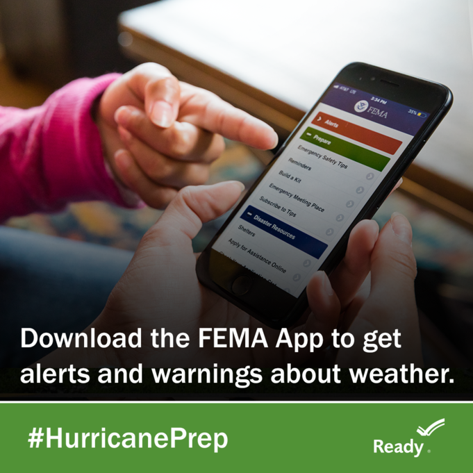person's hand with a cellphone showing the Fema App