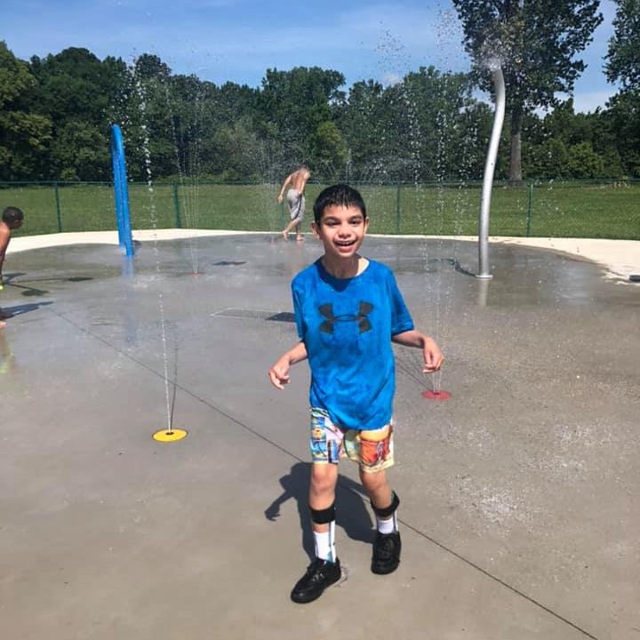 boy with intellectual and development disability playing in a splash