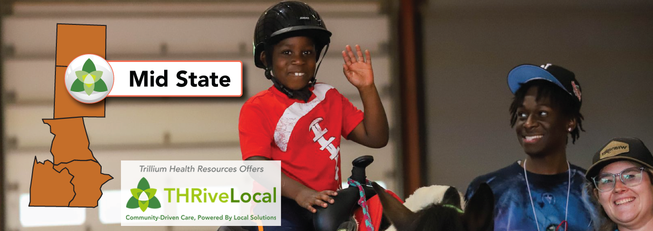  A kid riding a horse with help of a man and a woman