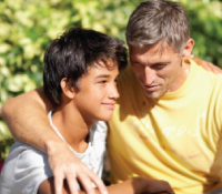 father and son hugging outside