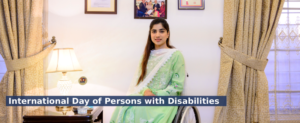 A woman sitting on a wheel chair on a living room posing and smiling to the camera