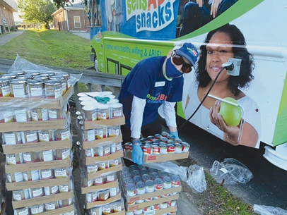 A young woman carring boxes to put them inside Food Truck