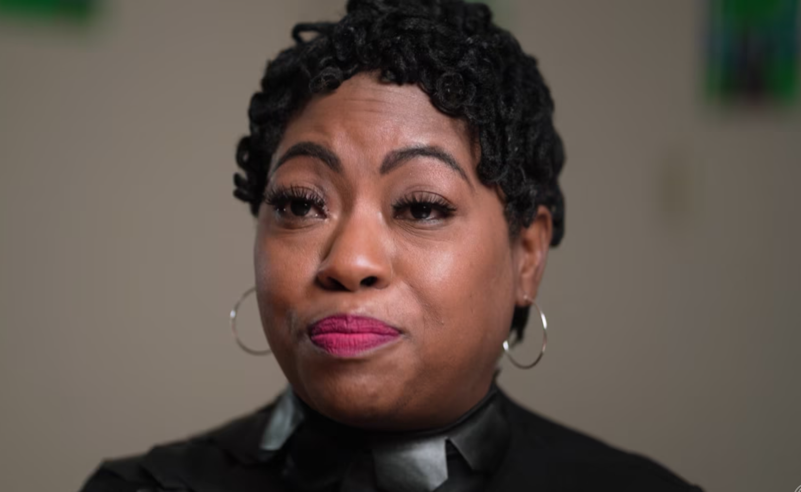 A woman with short hair talking about a subjet