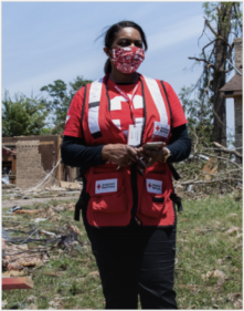 a woman working in FEMA standing in a disastre area