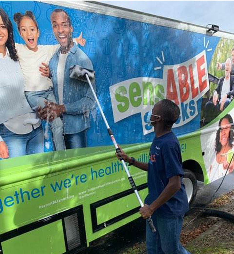 A young man cleaning a food truck