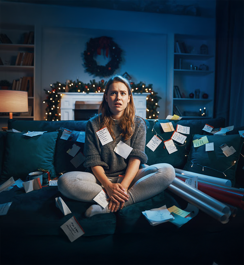 A picture of a woman on a living room full of post it, feeling stress