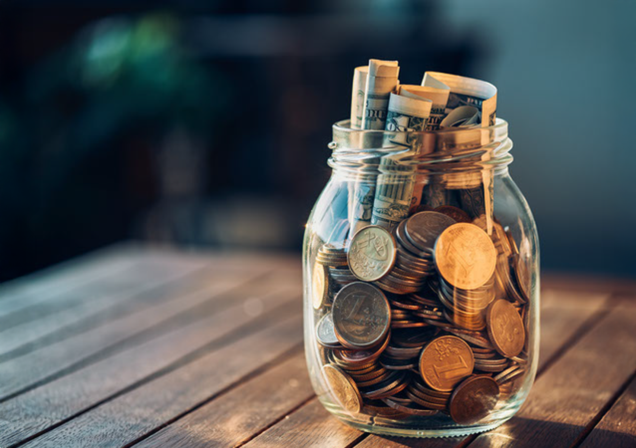 A jar full of coins and bills
