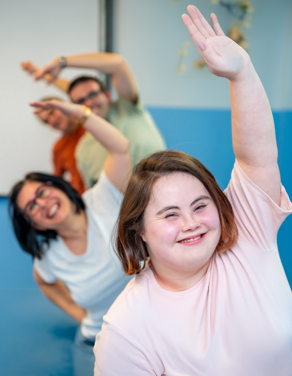 A young woman with down syndrome together with others doing yoga